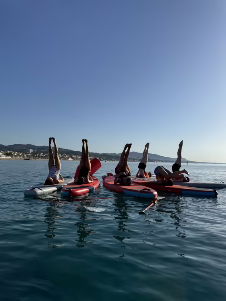 Postura de l'espelma fent Sup Yoga a la platja de Badalona